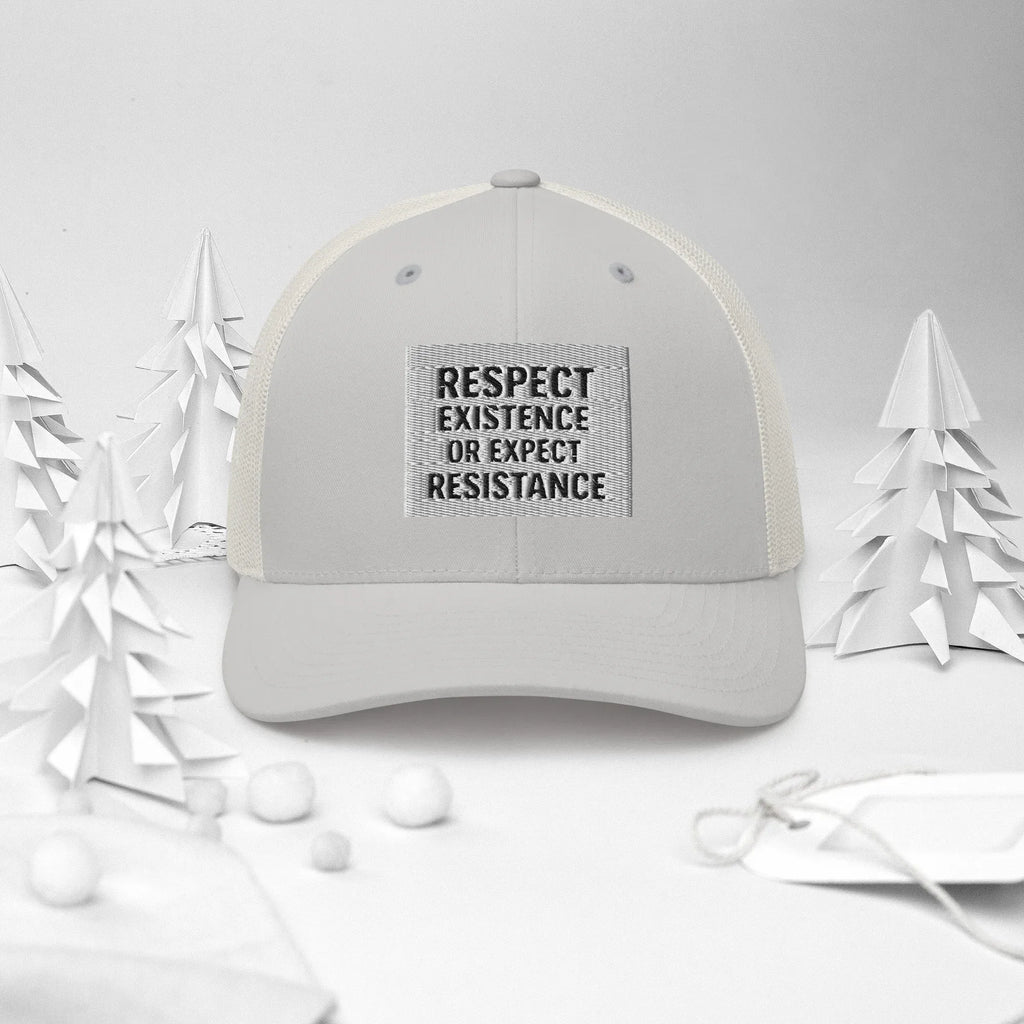 Urban Minaret Silver Trucker Hat on a winter-themed background with paper trees
