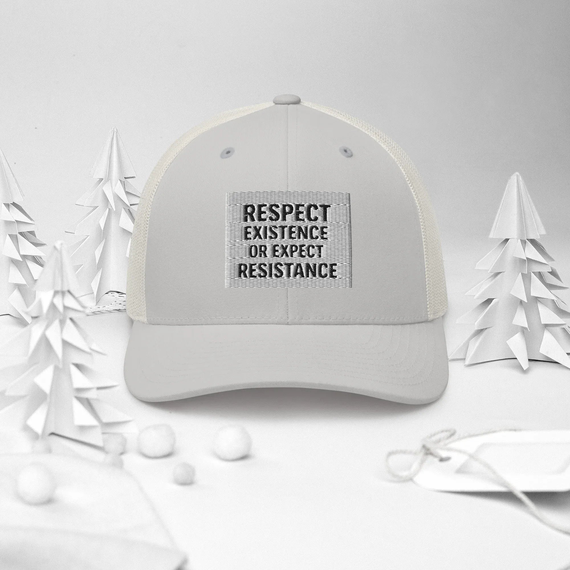 Urban Minaret Silver Trucker Hat on a winter-themed background with paper trees