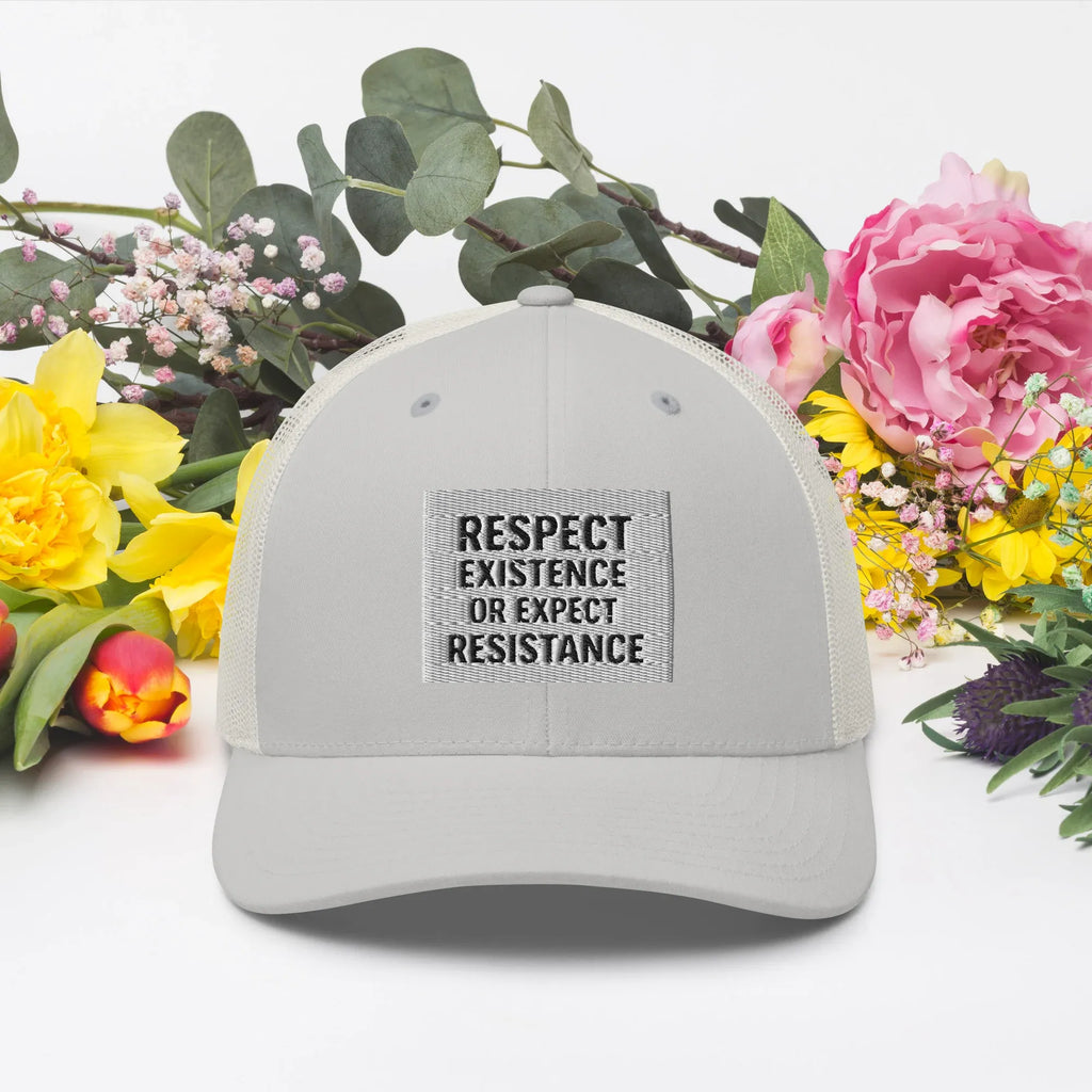 Stylish Silver Trucker Cap surrounded by colorful spring flowers and greenery